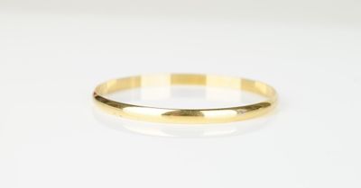 gros plan d'une bague en or sur une surface blanche
