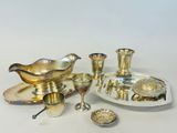 an assortment of silver plated items including a bowl, saucer, spoon, and other items