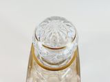 a clear glass jar with a gold lid on a clear surface