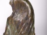 bronze sculpture of a woman sitting on her knees with a veil on her head