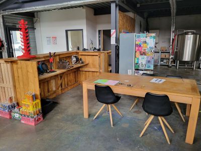 a table and chairs in a room with a refrigerator in the background