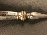 a silver pen sitting on top of a black leather bag