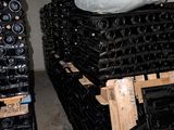 a pile of wine bottles on a pallet in a warehouse