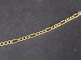 a close up of a gold chain on a black surface