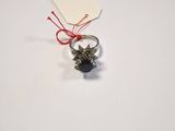 silver ring with black stone and red string on white surface
