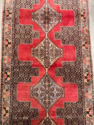a red and black rug with a design on it