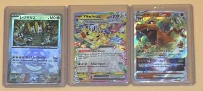 Trois types différents de cartes Pokémon sont accrochés au mur.