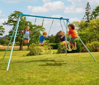 trois enfants jouant sur une balançoire dans un jardin