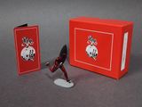 toy figurine of a man in a red outfit with a red box and a card