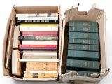 many books in a cardboard box on a white surface