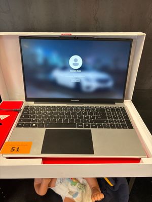une personne est assise devant un ordinateur portable posé sur un bureau