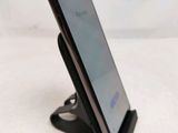 a close up of a cell phone on a stand on a table