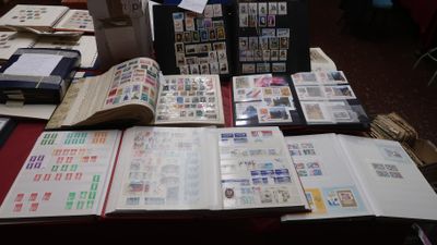 a lot of stamps on a table with a red table cloth