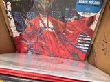 a person holding a box of vinyl records in a store