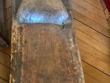 un banc en bois avec une assise en métal posé sur un plancher en bois