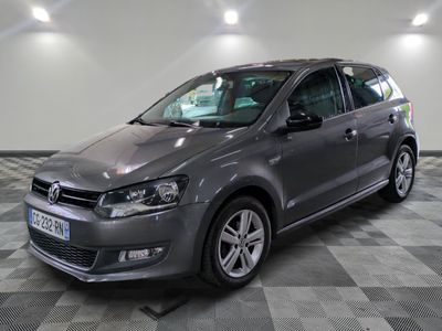 the grey volkswagen polo is parked on a checkered tile floor