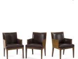 a set of three brown leather chairs sitting next to each other