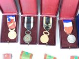 many medals in a red box on a white surface