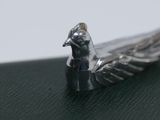a silver bird that is sitting on top of a table
