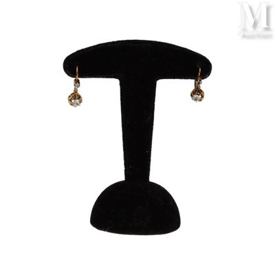a close up of a pair of earrings on a stand
