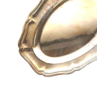 une assiette en argent posée sur une table, sur fond blanc