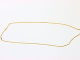 un collier en or avec une chaîne sur fond blanc