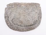 a silver purse that is sitting on a white surface
