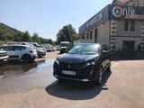 une voiture noire garée devant un bâtiment dans un parking