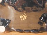 a black and gold plate with a teddy bear on it