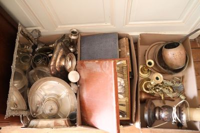une boîte remplie de vieux objets posée par terre
