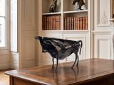 une statue représentant un oiseau posée sur une table dans un salon