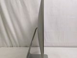 a computer monitor sitting on a stand on a white surface