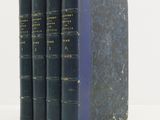 trois livres bleus empilés les uns sur les autres sur une surface blanche