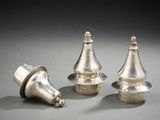 trois pièces d'argent sont posées sur une surface grise