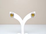 paire de boucles d'oreilles à clous en saphir jaune et diamants, présentées sur un socle blanc