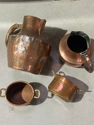 three cups and a pitcher sitting on a table next to each other