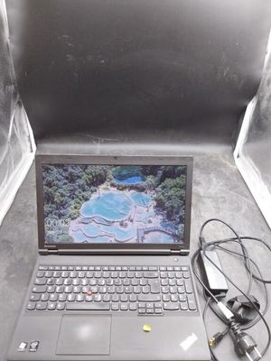 un ordinateur portable posé par terre, avec des câbles qui y sont branchés