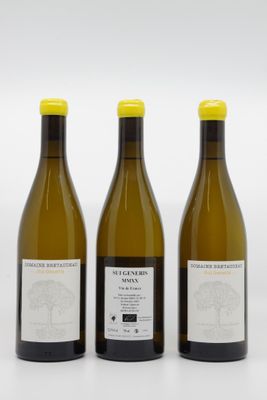 trois bouteilles de vin posées les unes à côté des autres sur une surface blanche