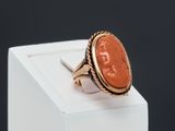 an image of a gold ring with an orange stone in the center