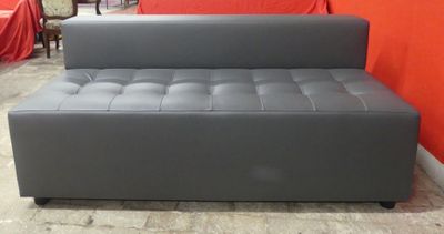 grey leather sofa bed in a room with a red wall