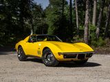 a yellow corvette car parked on a dirt road