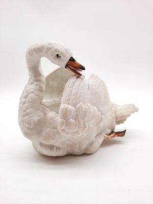 un cygne blanc posé sur un bol blanc