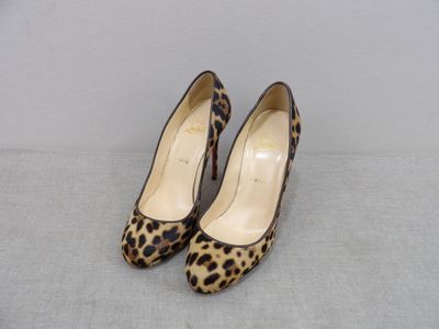 une paire d'escarpins à imprimé léopard posés sur une surface grise