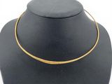 a black necklace with a gold chain on a mannequin neck