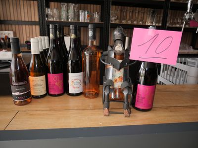 many bottles of wine on the counter with a sign