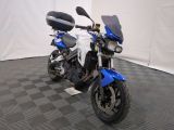 une moto bleue et blanche garée sur un sol à damier noir et blanc