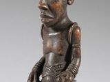 l'image d'une statue en bois représentant un homme avec un chapeau sur la tête