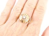 a woman ' s hand holding a ring with a diamond on it