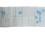 un gros plan sur une serviette blanche ornée de fleurs bleues