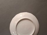 a white plate on the table next to a cup